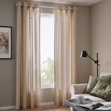 Rideaux floraux beiges, chaise blanche aux accents verts, lampe noire.