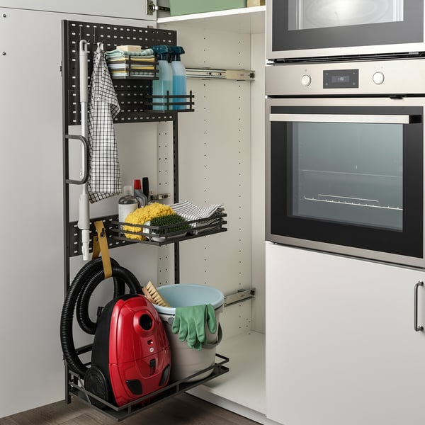 Armoire de nettoyage organisée avec étagère, serviettes, éponges et aspirateur pour un accès facile.