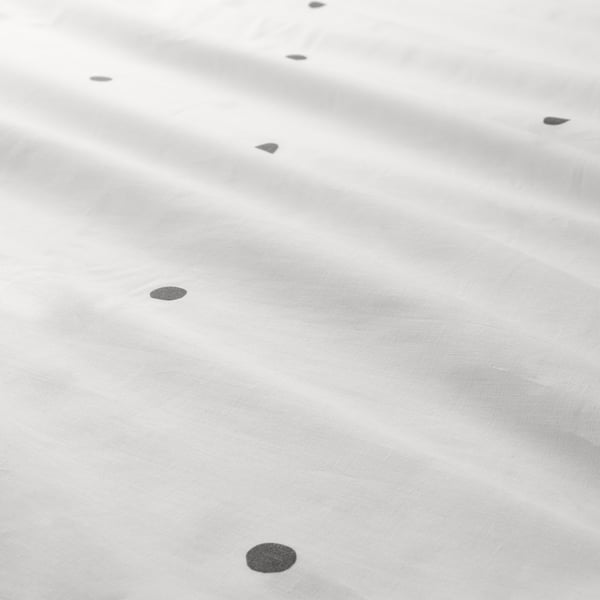 Points noirs sur matière légère. Texture douce et uniforme avec fermeture éclair.