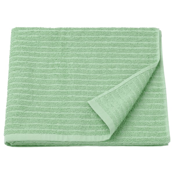 Une serviette VÅGSJÖN verte pliée, douce et absorbante, 100 % coton, avec une texture côtelée.