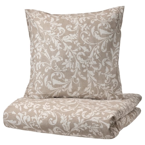 Parure de lit VÅRBRÄCKA beige à motif floral blanc, en coton doux, avec housse de couette et taies d’oreiller aux imprimés élégants.