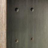 Quatre capuchons circulaires recouvrent les trous de perçage dans une surface sombre, ce qui les rend moins visibles et donne un aspect fini.