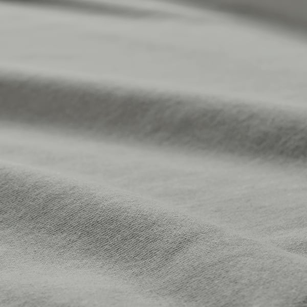 Gros plan en noir et blanc d’un tissu de coton doux et texturé, mettant en valeur son tissage lisse et ses plis doux.
