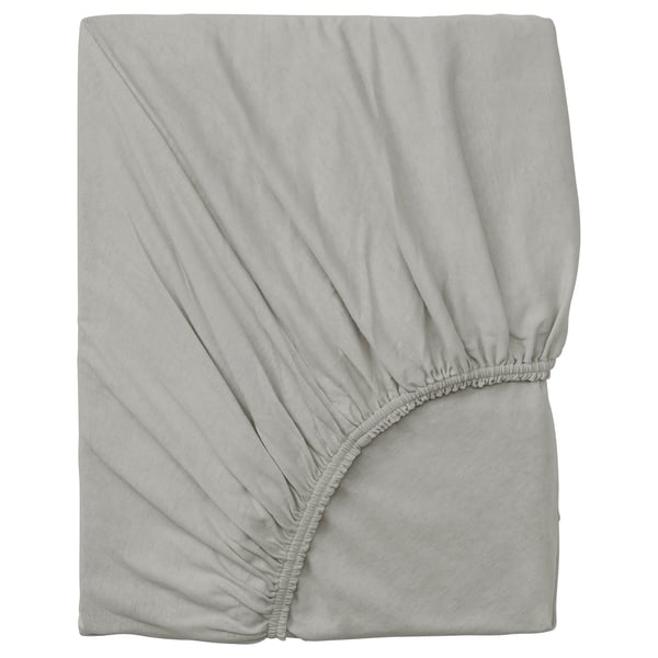 Un drap-housse gris 100 % coton, soigneusement plié, avec des bords élastiques pour un ajustement sûr.