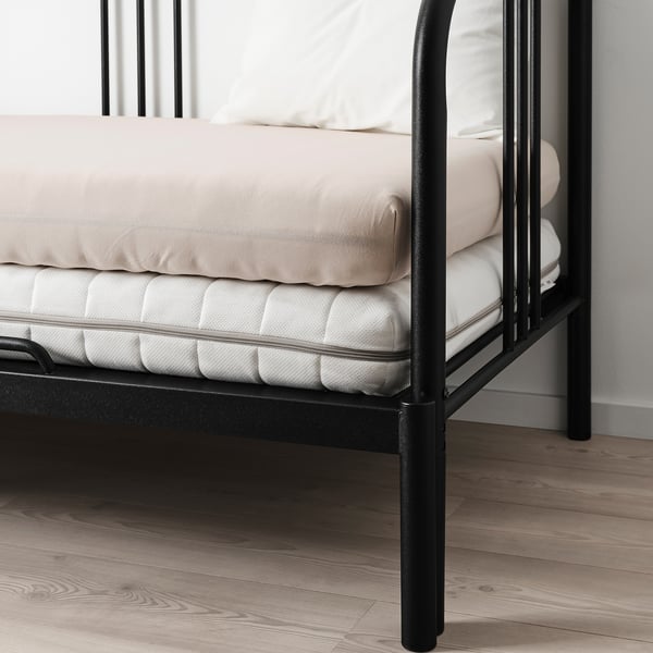 Cadre de lit en métal noir avec un matelas, avec un drap en jersey de coton extensible.