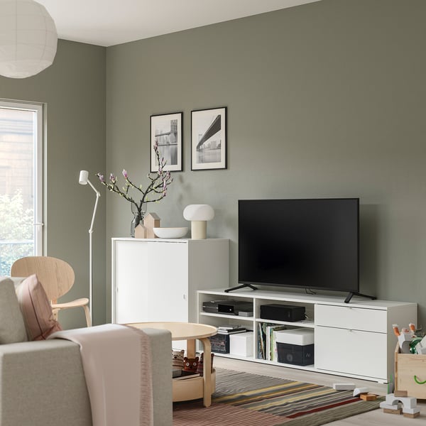 Salon moderne avec combo de rangement blanc VIHALS, comprenant un meuble TV et une armoire. Téléviseur, lampe et décoration placés au centre.