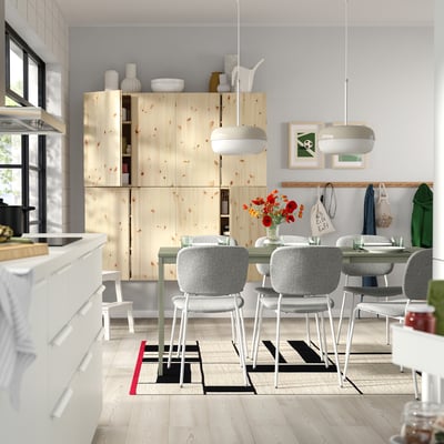 Cuisine moderne avec armoires en bois, ensemble de salle à manger gris près de grande fenêtre.