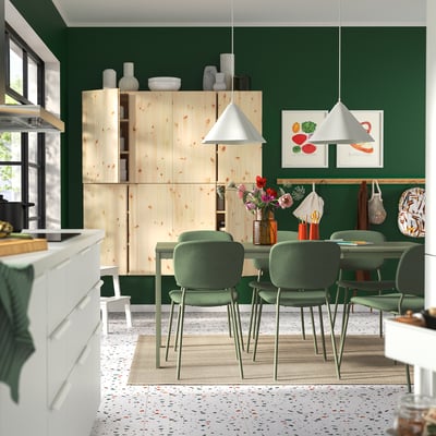 Cuisine moderne avec des chaises vertes VIHALS, des armoires en bois, un sol en terrazzo et des suspensions blanches.