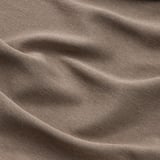 Une vue rapprochée d’épais rideaux texturés et beiges. Motif tissé visible, mettant en valeur la qualité du tissu dense.