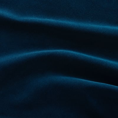 Section de canapé en velours bleu profond, présentant une texture luxueuse, douce et veloutée avec une brillance subtile et réfléchissante.