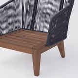 Fauteuil d’extérieur de haute qualité avec cadre en bois, dossier en corde et coussin moelleux, conçu pour le confort et la durabilité.