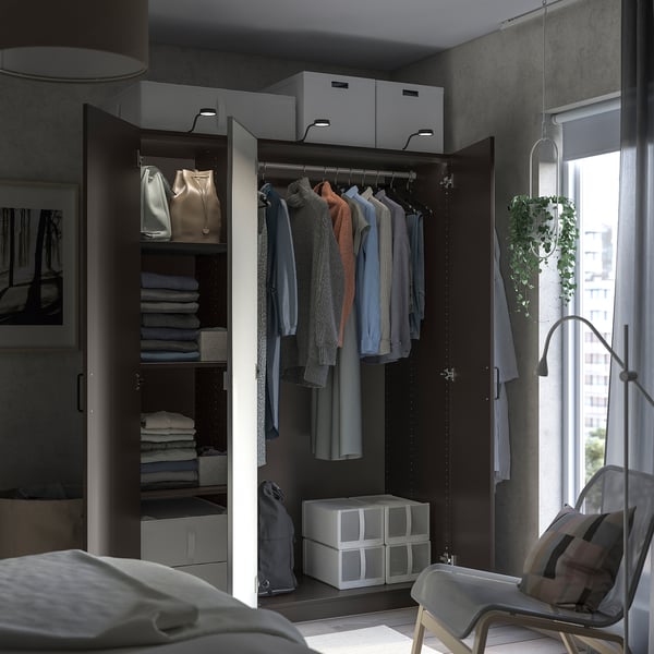 Placard moderne avec rangement élégant, vêtements et lampe.