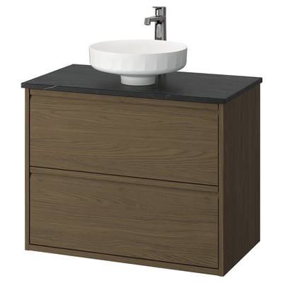 Modern wooden bathroom vanity with black countertop and white bowl sink.