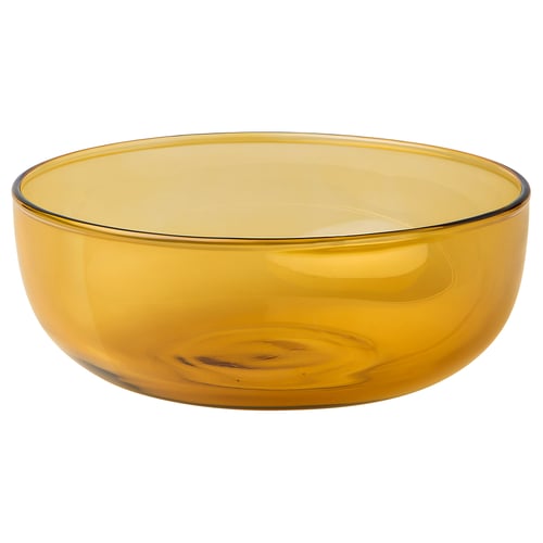 This image shows an AROMATISK yellow glass bowl. Its mouthblown with an organic shape. The bowl is elegant and suitable for serving or decoration.