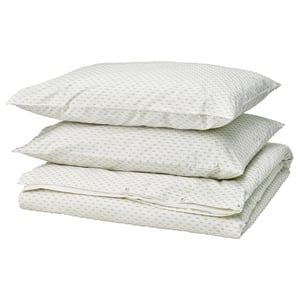 Stack of 3 white pillows with green dots, neatly folded. Made of cotton.