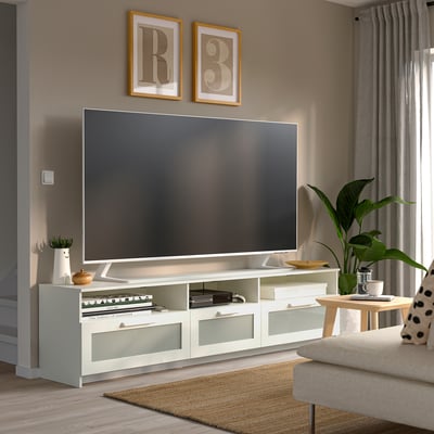 Modern living room with white BRIMNES tv stand, tv, plants, art, sofa, side table.