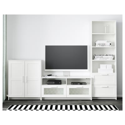 Modern living area with white furniture: tv on stand, storage drawers, adjustable shelves, and cable management. Black and white striped rug.