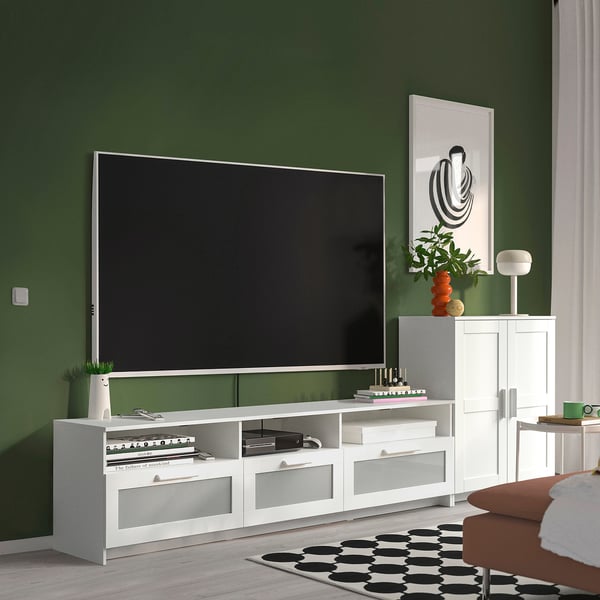 Modern living room with BRIMNES tv stand, dark green walls, & cosy setup.
