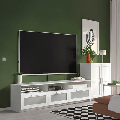Modern living room with BRIMNES tv stand, dark green walls, & cosy setup.