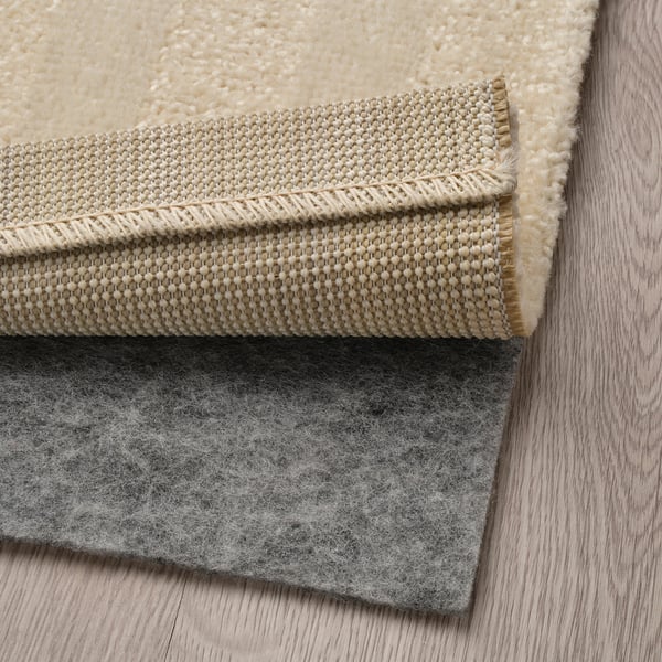 Thick rug with anti-slip backing on wooden floor.