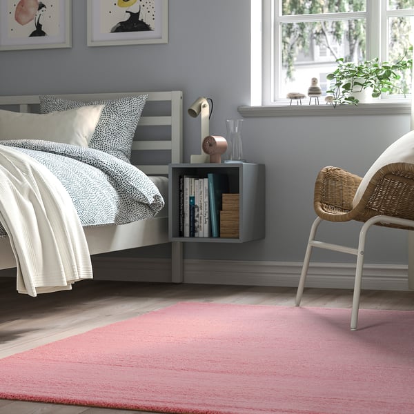A cosy pastel pink rug named LANDSVÄG, soft and low-pile, fits under the bed. Its stripes add texture, matching neutral tones and providing warmth.