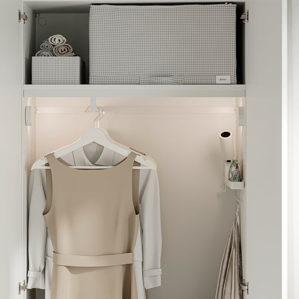 Closet with hanging beige dress, rolled towels in box, mesh drawer labelled notic.