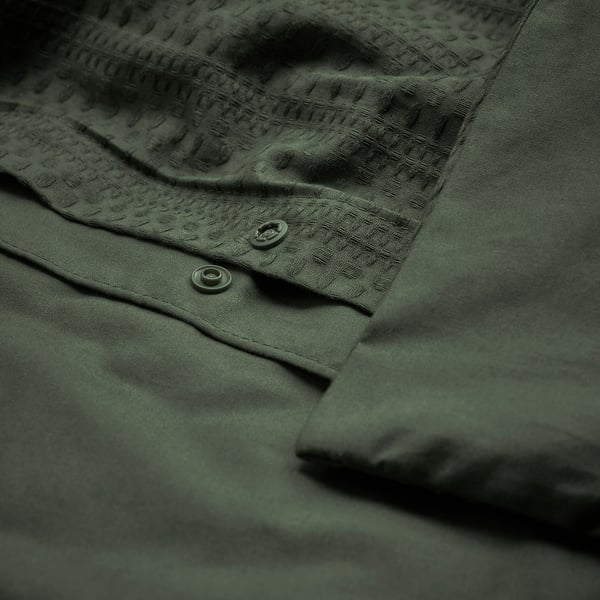 Dark green duvet cover with waffle texture and recycled cotton detail.