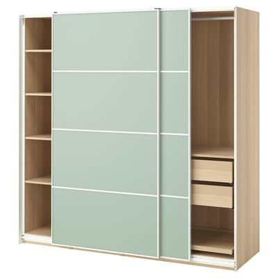 An ikea PAX wardrobe, light green with wooden shelves and drawers.
