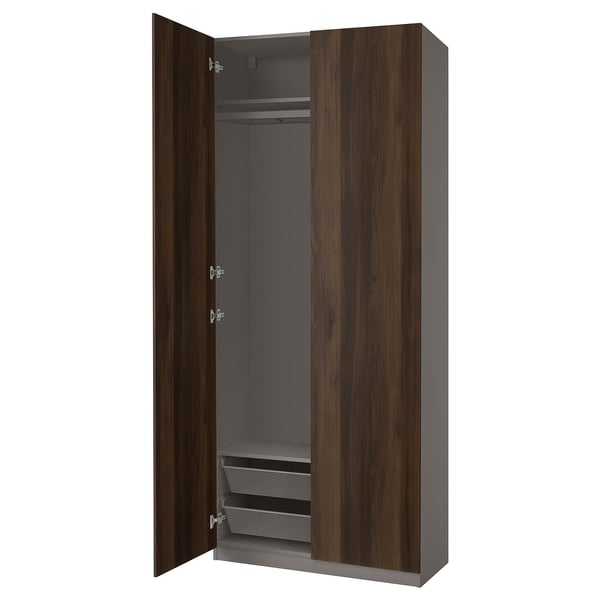 Open PAX wardrobe: dark wood, grey shelves, asymmetrical doors with soft-close hinges.