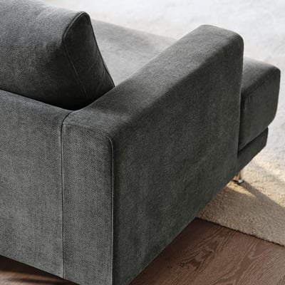 Dark grey upholstered sofa, modern style, clean lines, soft fabric, cosy cushions, quality design.
