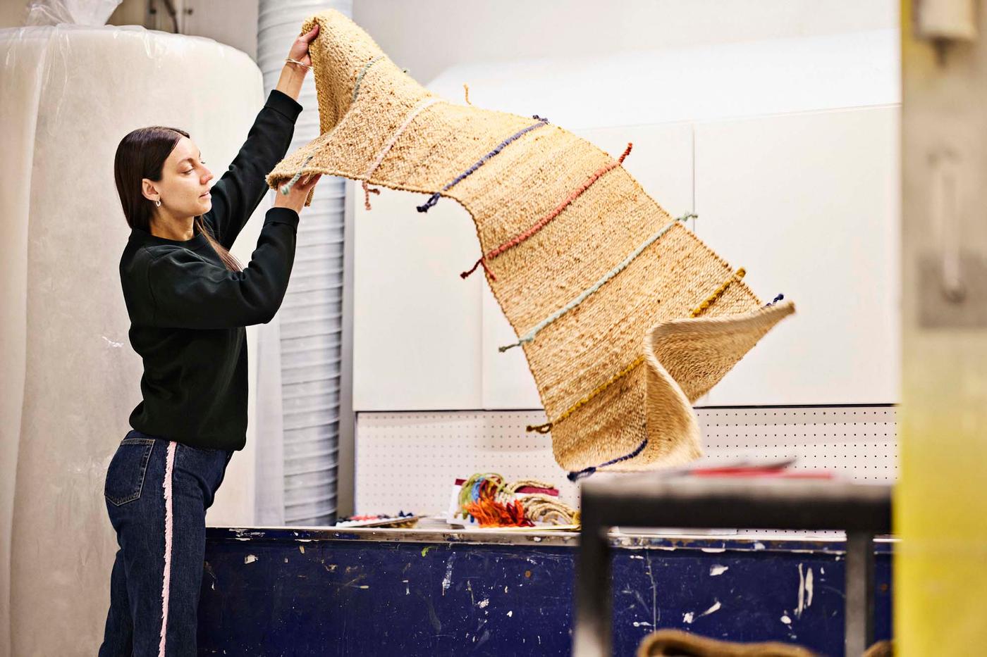 Paulin Machado shakes out a RAKLEV rug.