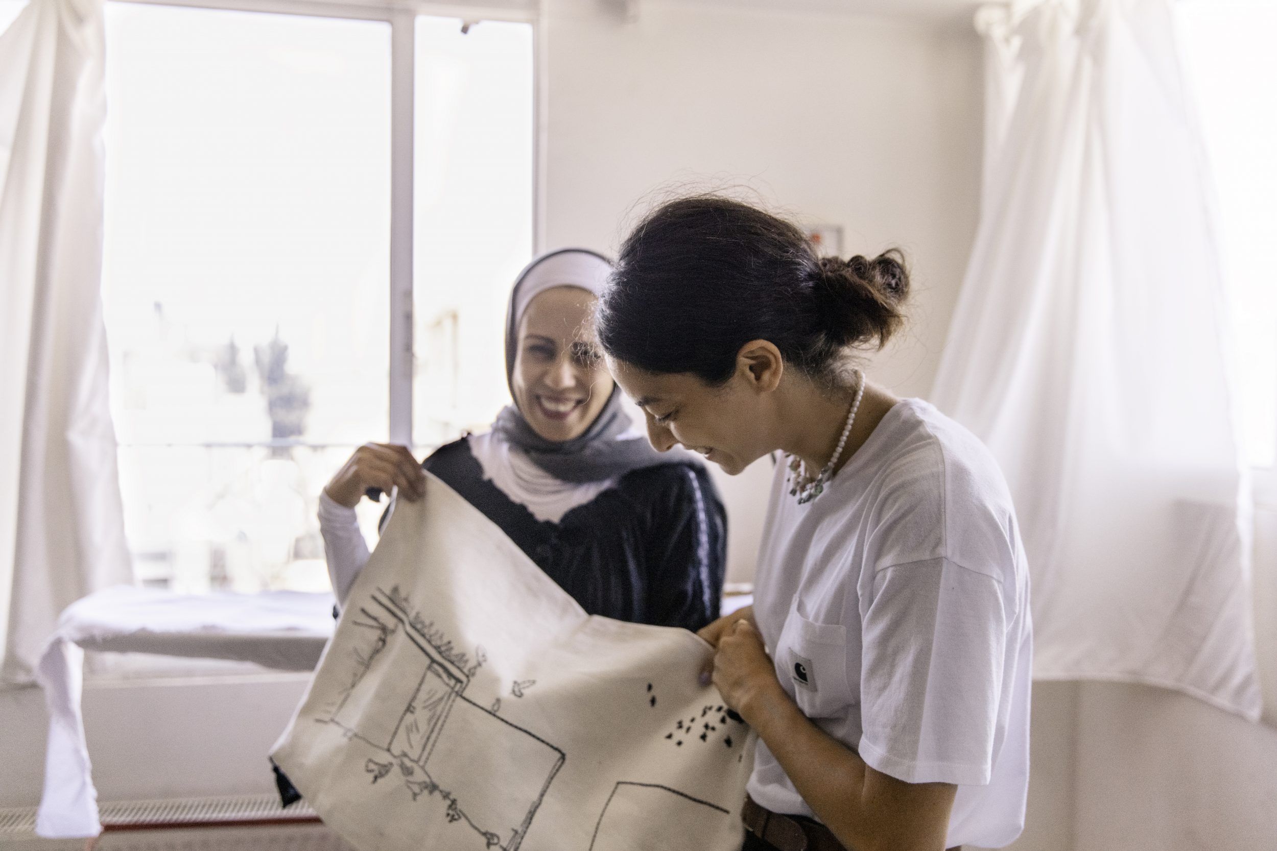 Two women artisans and their embroideries.