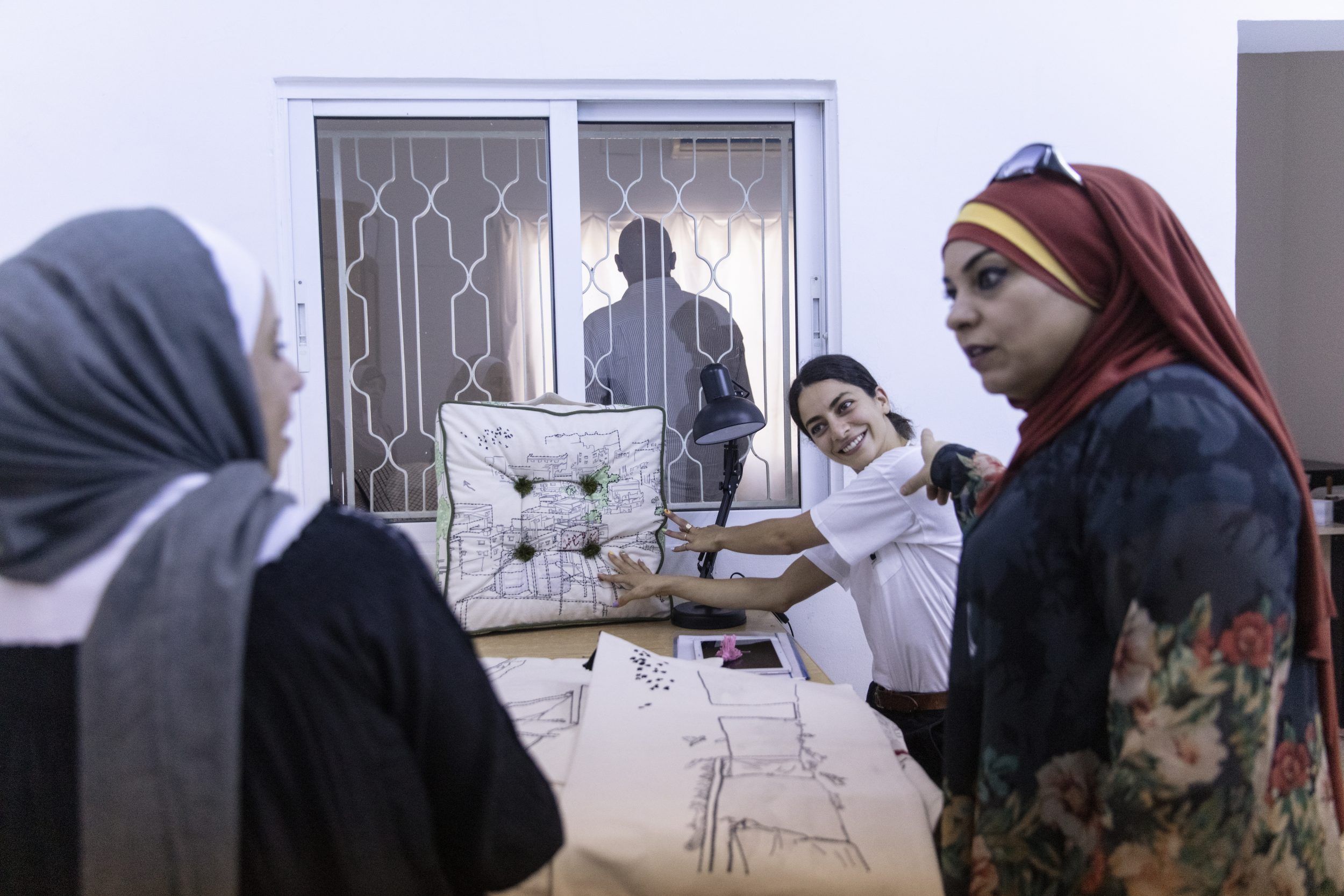 A group of women artisans with embroidered items.
