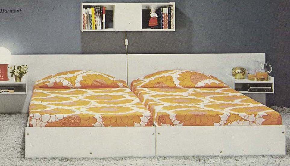 An image from the 1971 IKEA Catalogue showing two single beds together. Each bed has orange sunflower bedlinen.