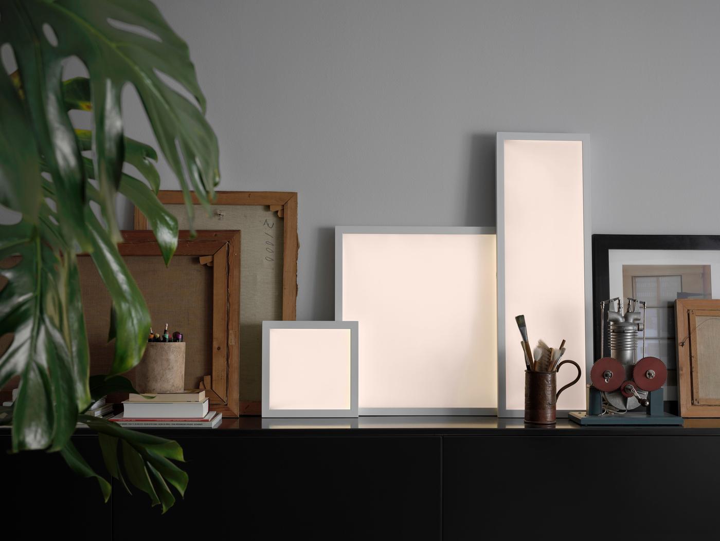 A surface filled with photo frames, ornaments and illuminated framed panels.