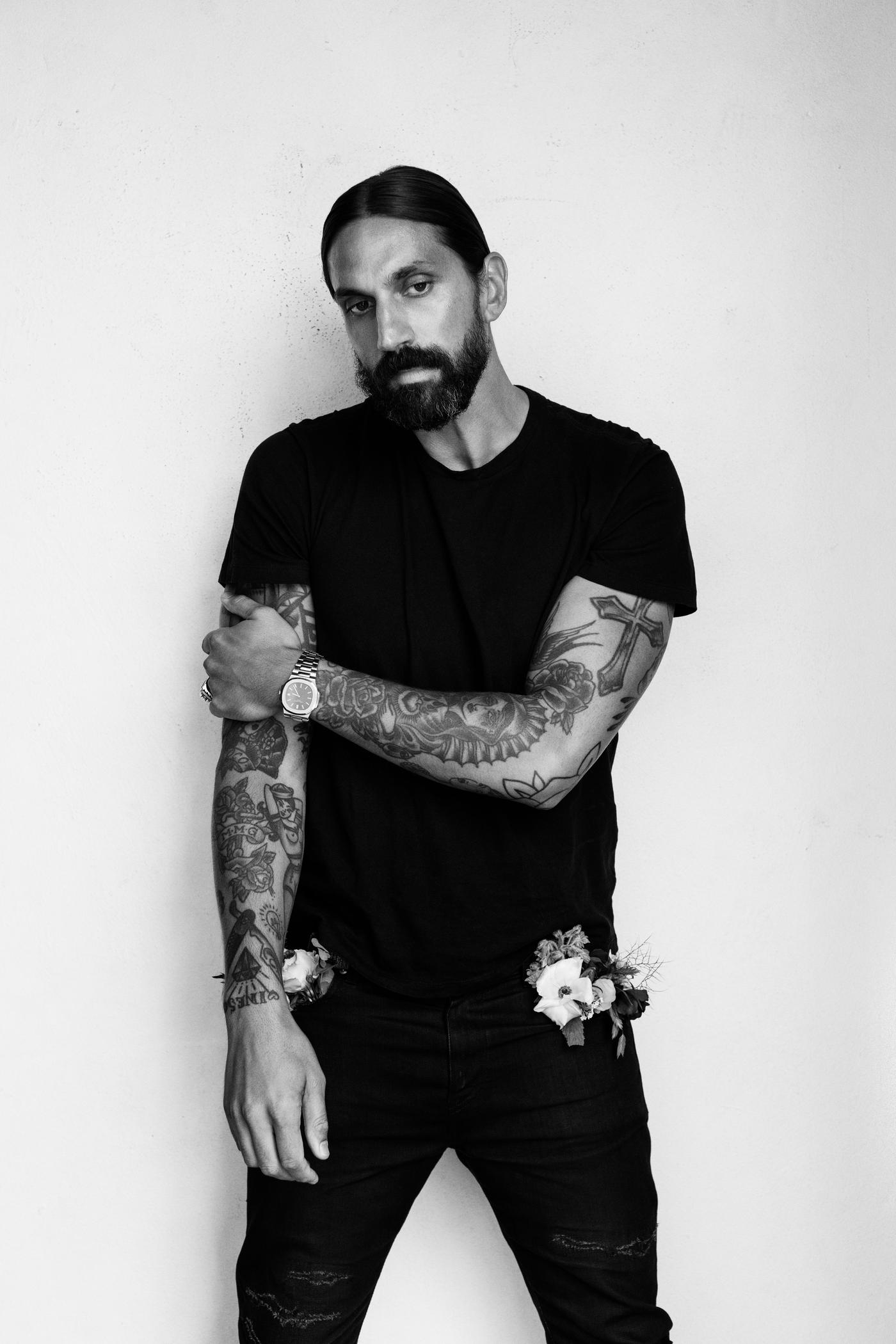 Ben Gorham dressed in black, standing with one hand gripping his opposite arm.