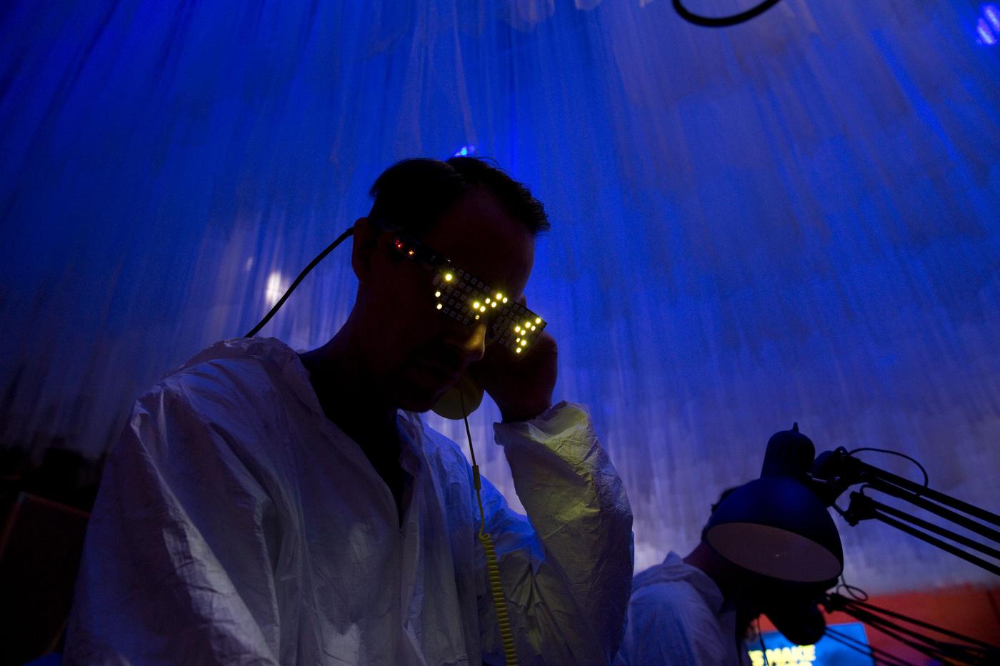 A person wears VR goggles in a dark blue lit room