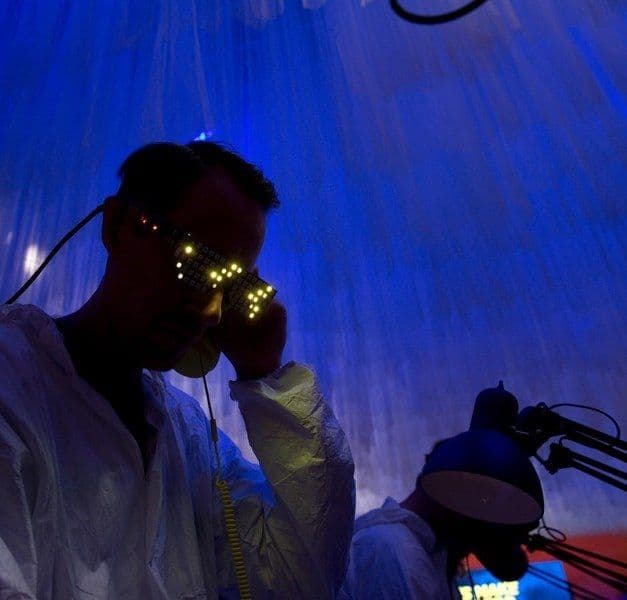 A person wears VR goggles in a dark blue lit room