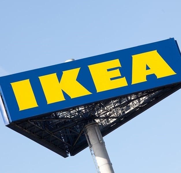 A blue and yellow IKEA store sign against a blue sky.