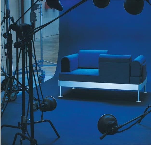 A sofa against a backdrop in a photo studio setting.