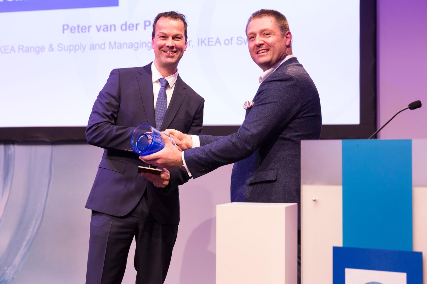 Two people shaking hands during an awards ceremony.