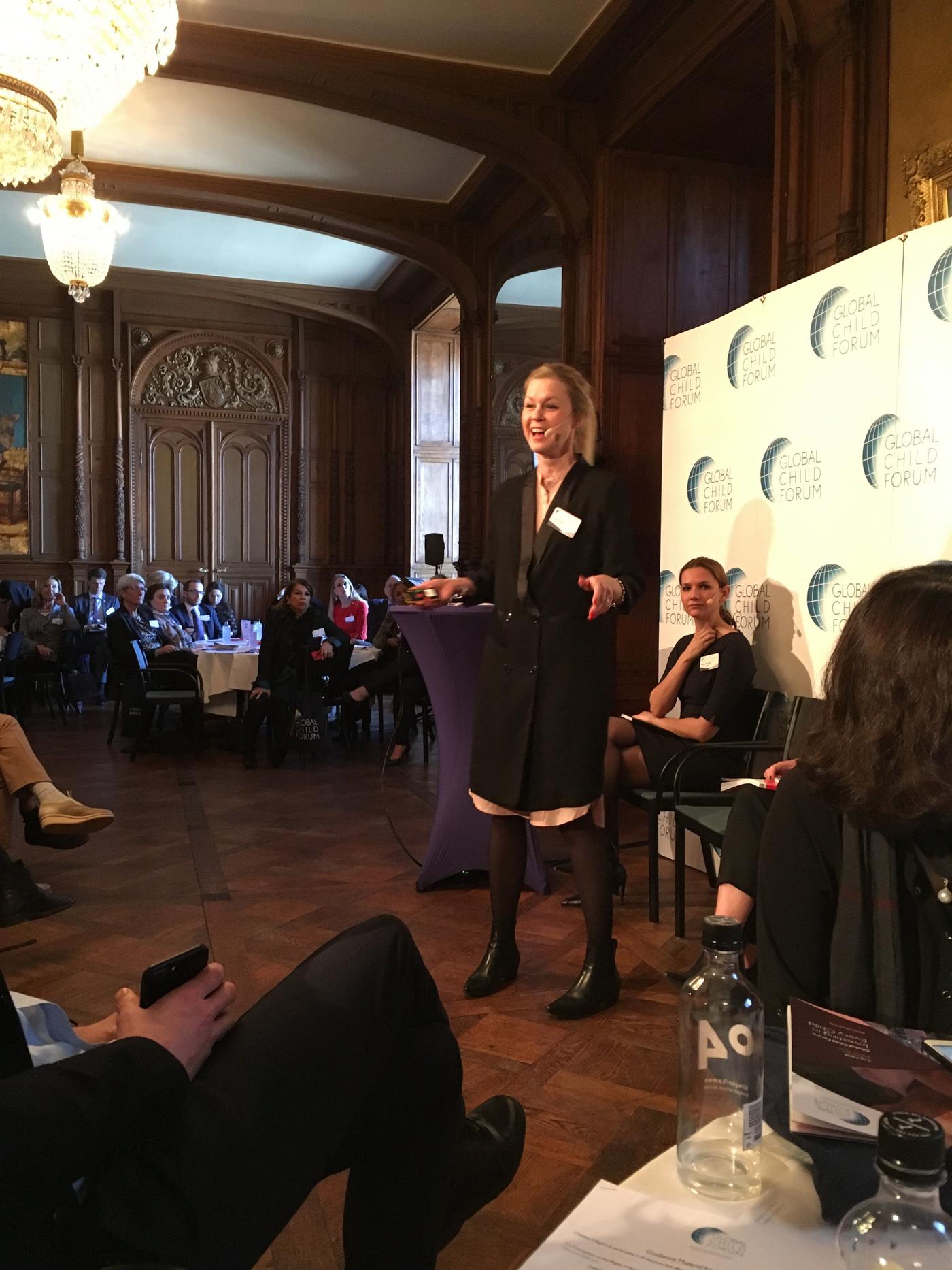 Fredrika Inger stands presenting on a stage.