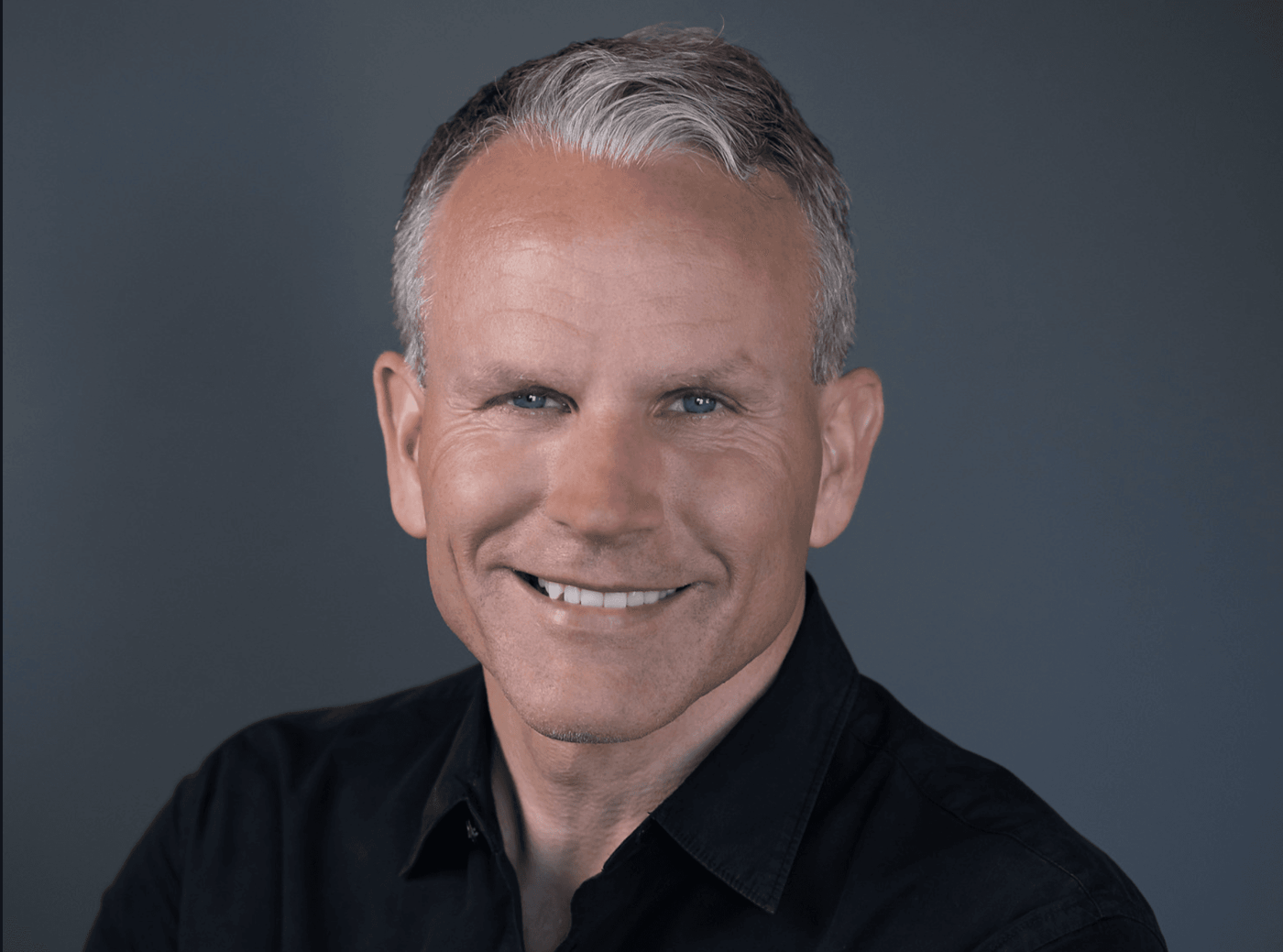 Portrait of Eythor Bender, smiling and wearing a black shirt.