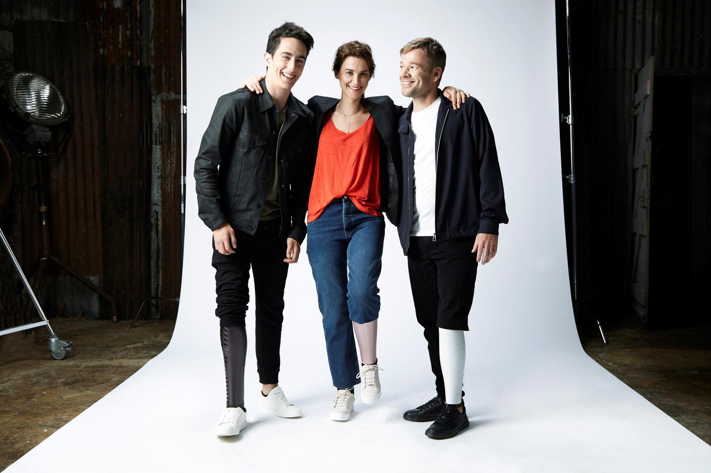 Three people standing together on a white infinity backdrop in a photo studio.