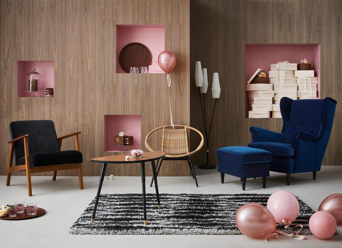 A living room with IKEA furniture and many pink balloons.