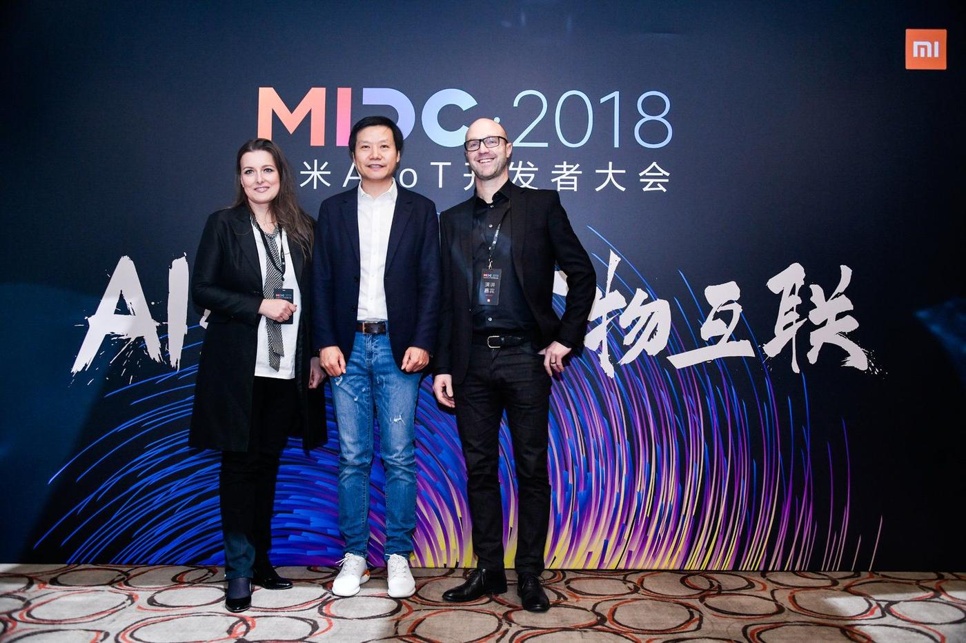 Three people stand together in front of a backdrop reading "MIDC AIoT 2018".