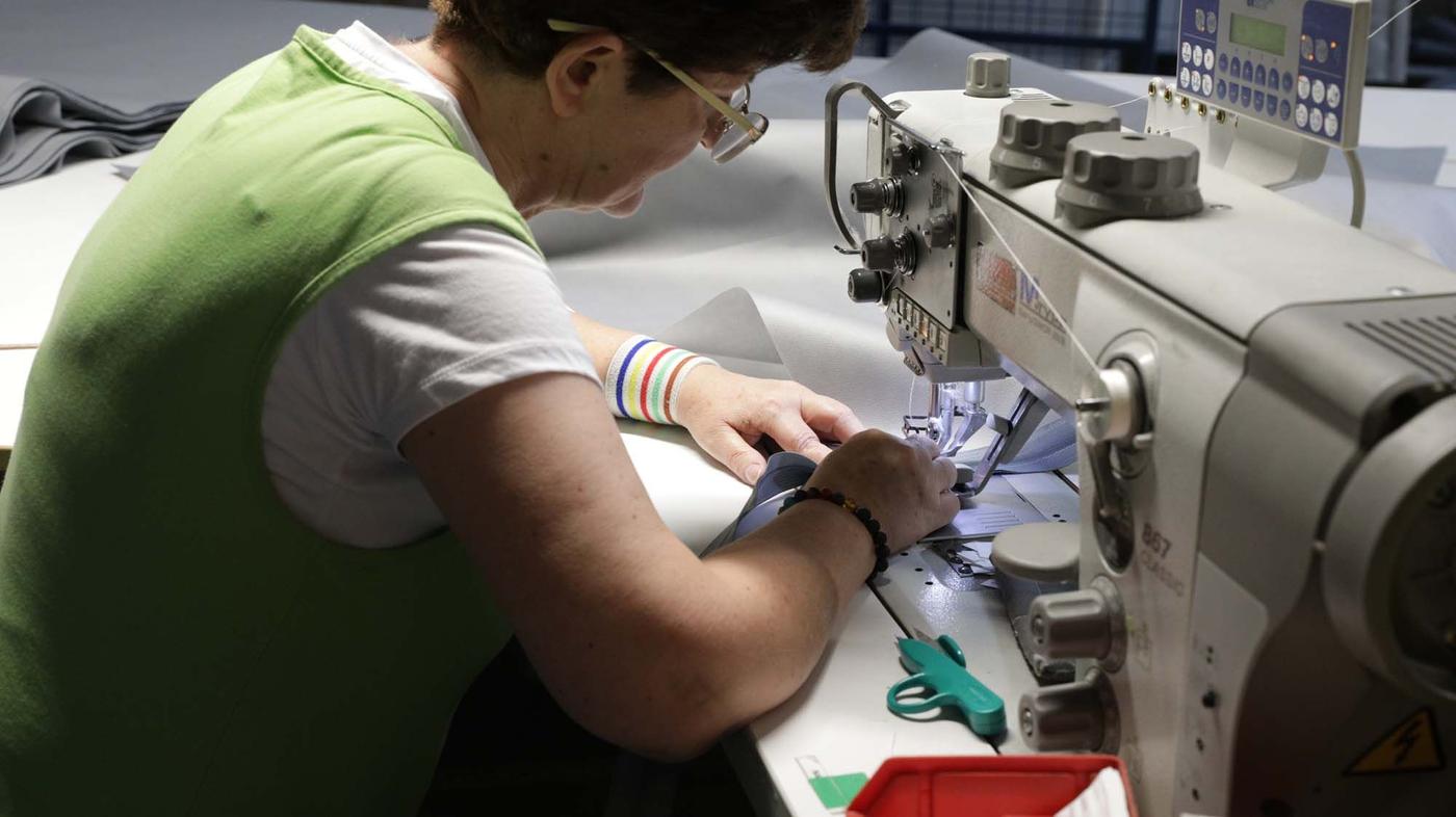 A person sews on a sewing machine.