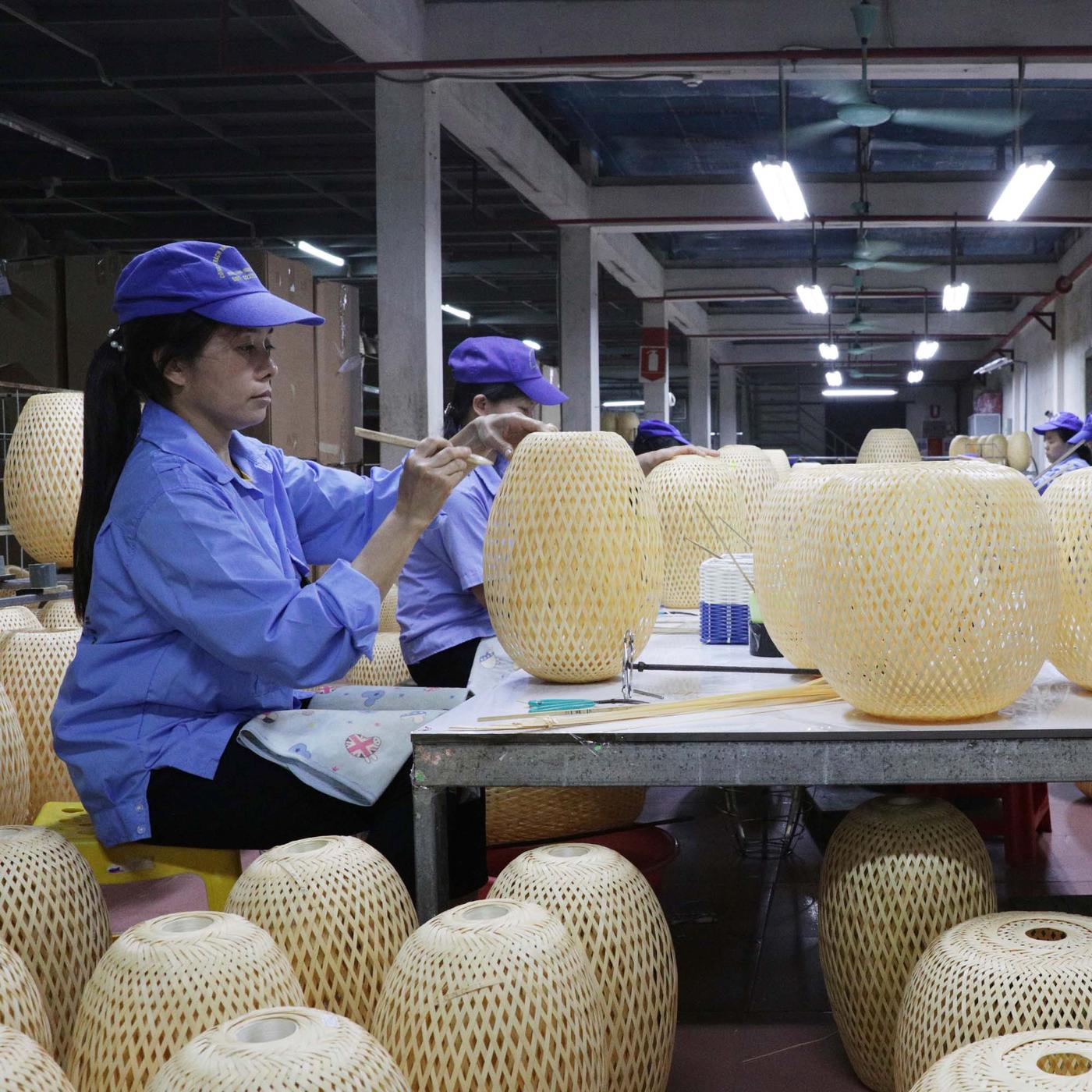 A factory worker examining a product on the factory floor.