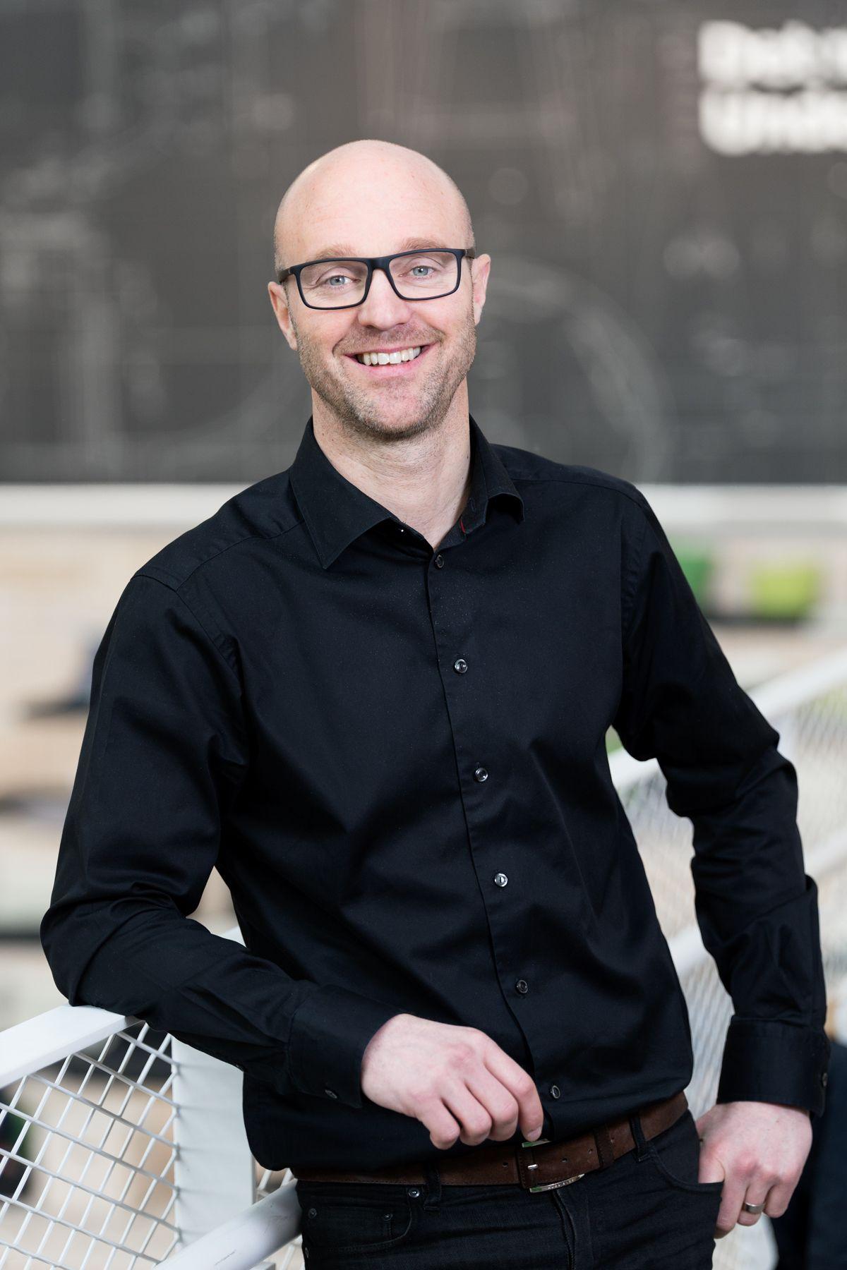 Portrait of Björn Block wearing glasses and a black shirt.