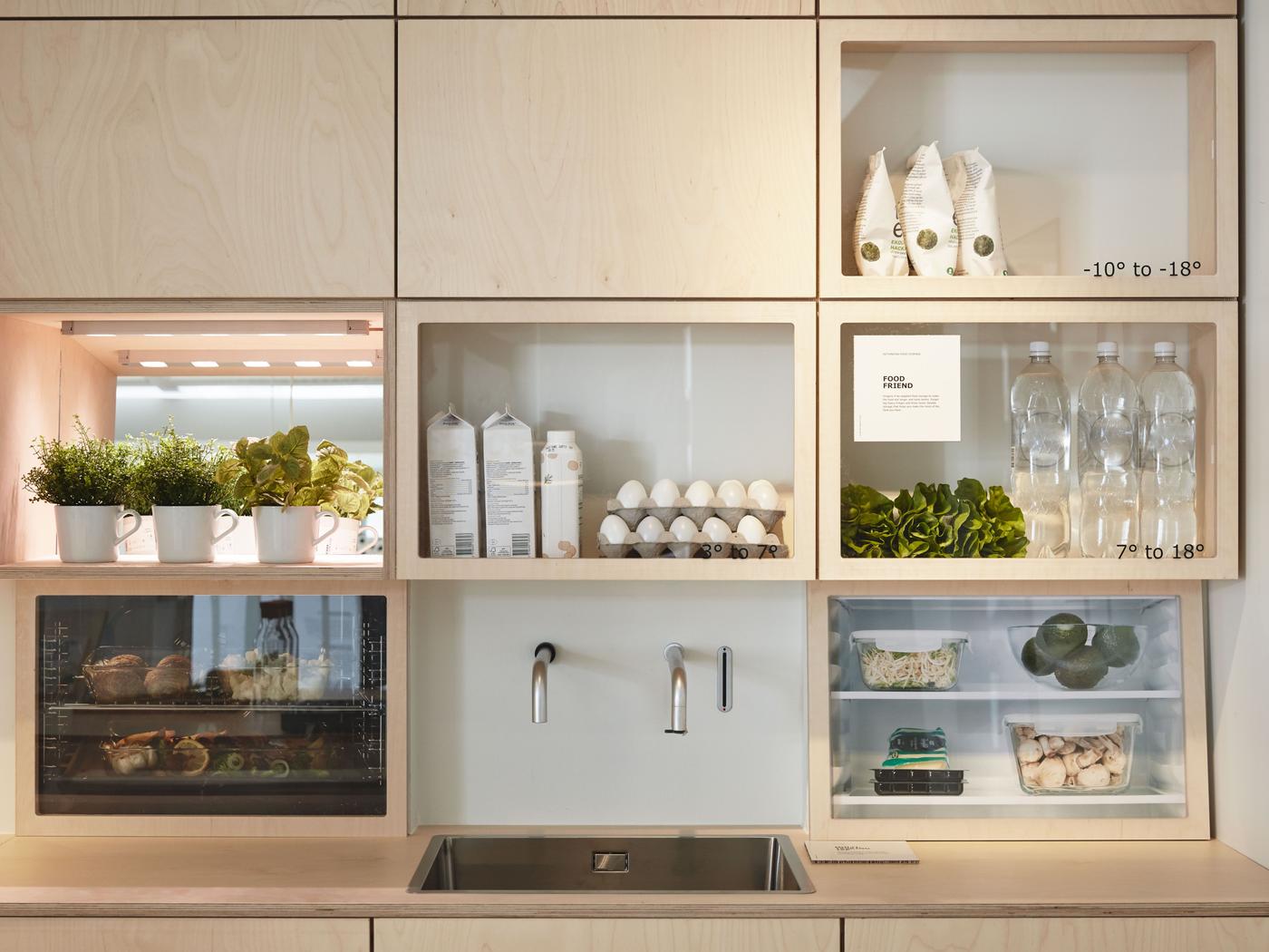 Compact kitchen with light wood fronts and a mix of open and closed overhead cabinets.